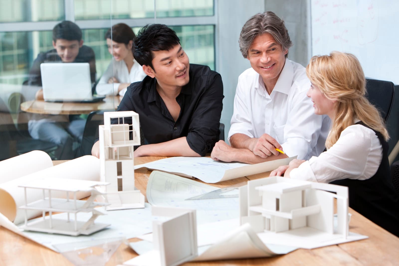 Design team reviewing drawings and architectural models