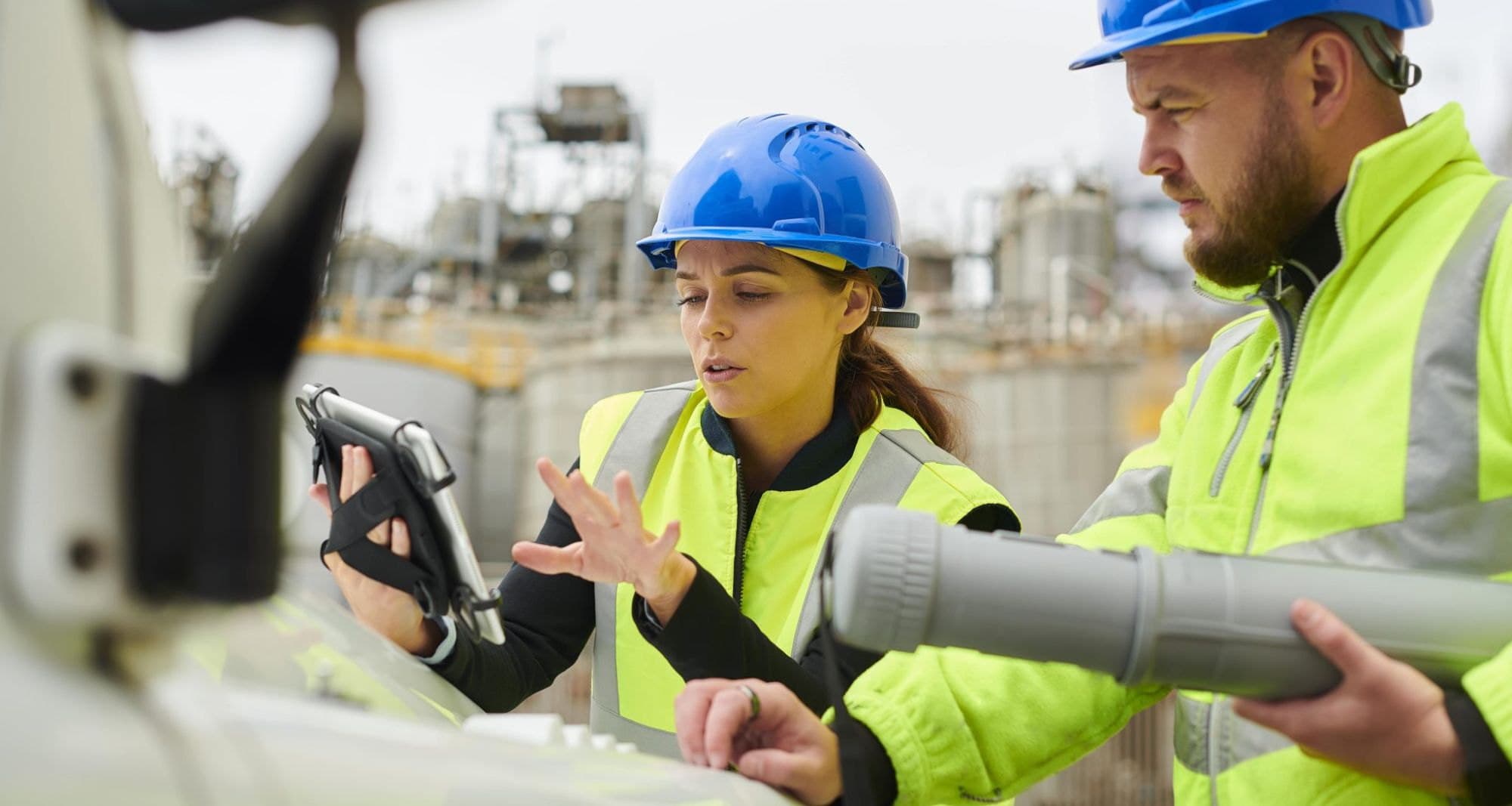 Construction professionals reviewing site arrangements on a tablet during a CDM compliance check