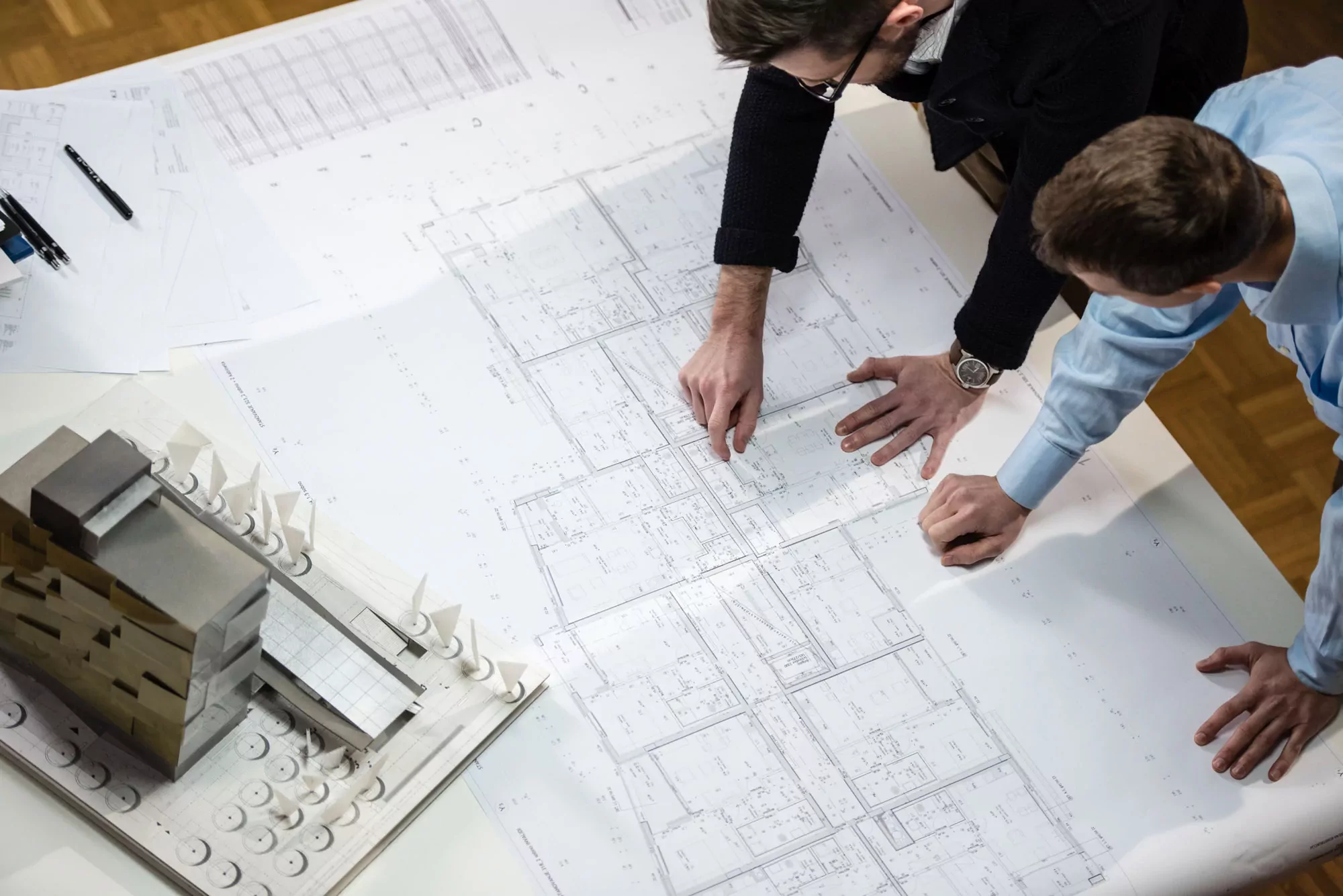 Design professionals reviewing architectural plans during pre-construction coordination