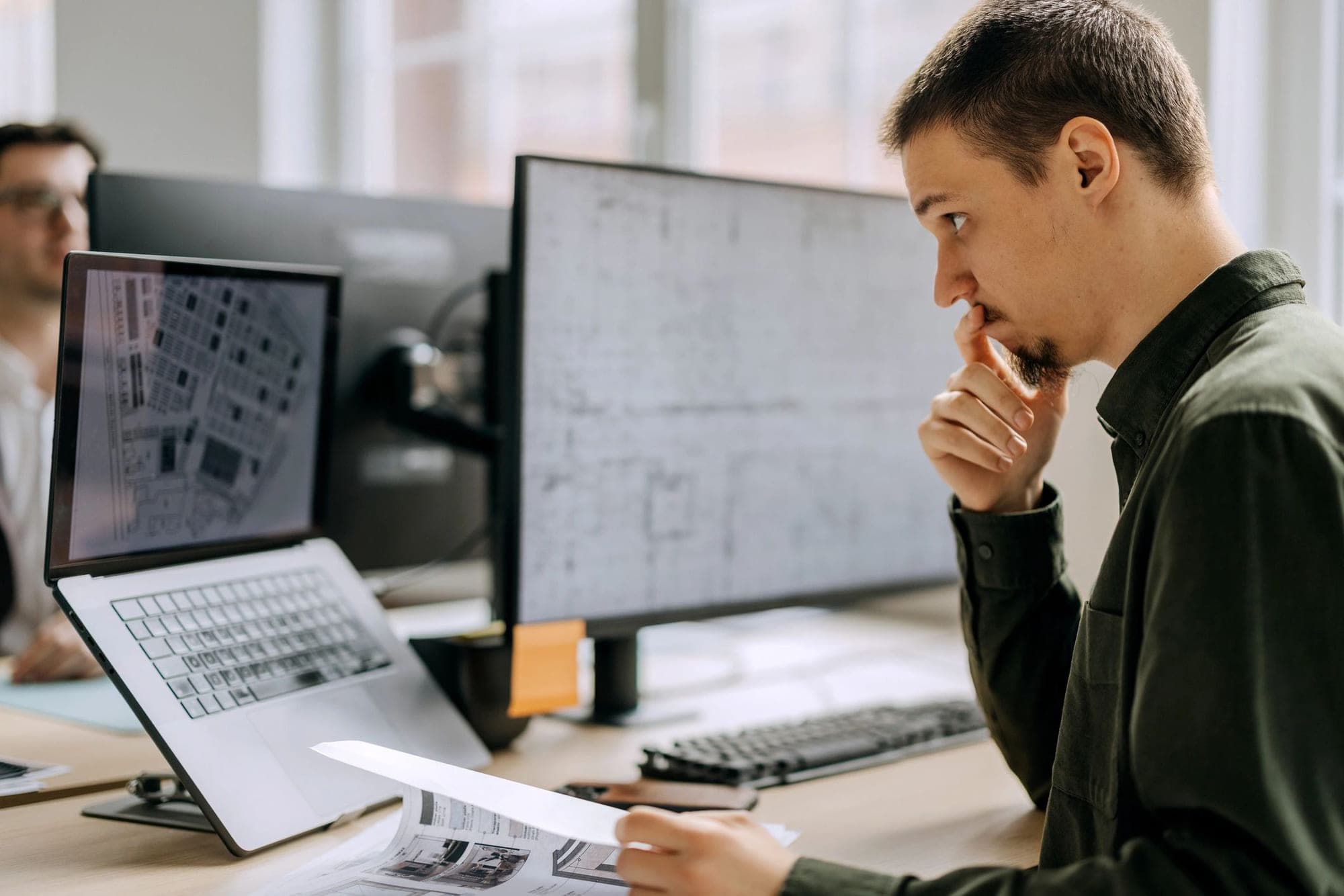 Designer reviewing technical drawings and digital plans for a construction project